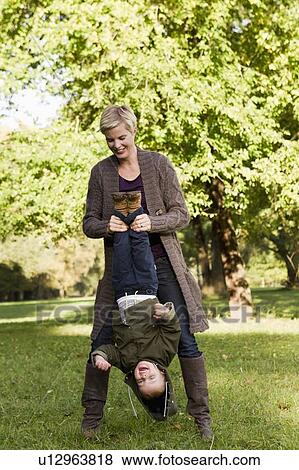 Stock Photo - Mother and son playing in park. Fotosearch
