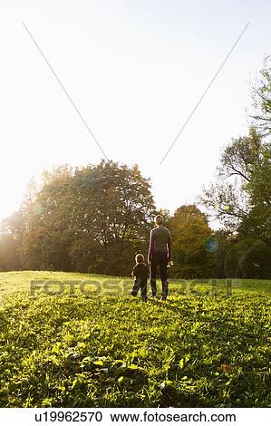Mother and son walking in park View Large Photo Image Stock Image - Mother and son walking in park. Fotosearch