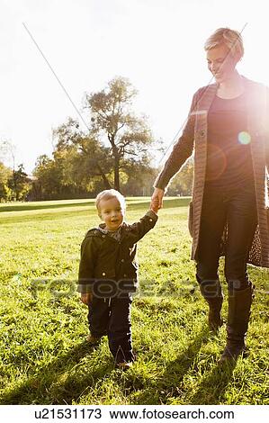 Mother and son walking in park View Large Photo Image Stock Image - Mother and son walking in park. Fotosearch