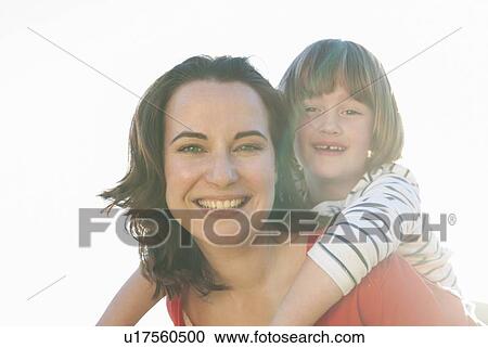Stock Image - Mother carrying daughter outdoors. Fotosearch