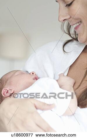 Mother cradling infant son View Large Photo Image Stock Photo - Mother cradling infant son. Fotosearch