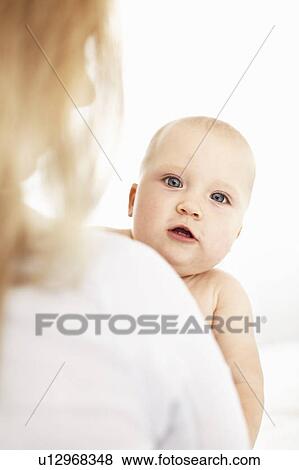 Mother holding curious baby girl View Large Photo Image Stock Photo - Mother holding curious baby girl. Fotosearch