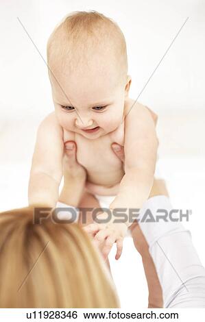 Mother holding laughing baby girl View Large Photo Image Stock Photograph - Mother holding laughing baby girl. Fotosearch