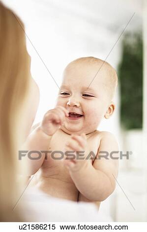 Stock Photography - Mother holding laughing baby girl. Fotosearch