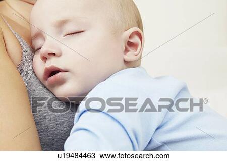 Mother holding sleeping baby girl View Large Photo Image Stock Image - Mother holding sleeping baby girl. Fotosearch