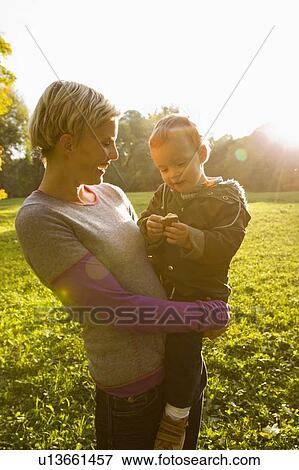 Stock Photo - Mother holding son in park. Fotosearch