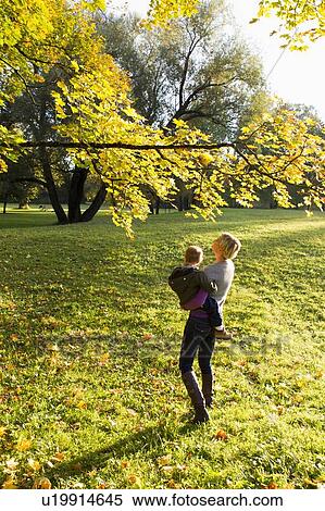 Mother holding son in park View Large Photo Image Stock Photography - Mother holding son in park. Fotosearch