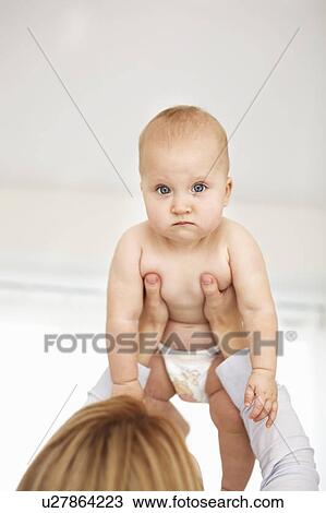 Mother holding upset baby girl View Large Photo Image Stock Image - Mother holding upset baby girl. Fotosearch