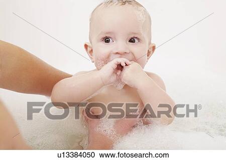 Mother washing baby girl in bubble bath View Large Photo Image Stock Image - Mother washing baby girl in bubble bath. Fotosearch