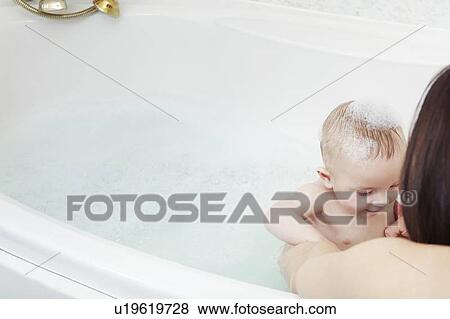 Mother washing baby girl in bubble bath View Large Photo Image Stock Photo - Mother washing baby girl in bubble bath. Fotosearch