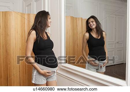 Pregnant woman admiring herself View Large Photo Image Stock Image - Pregnant woman admiring herself. Fotosearch