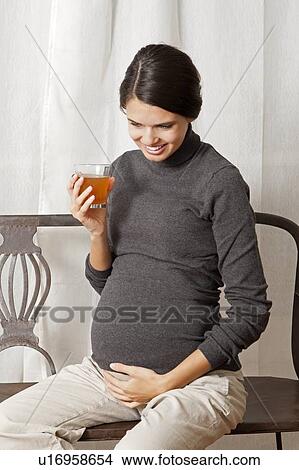 Picture - Pregnant woman drinking juice. Fotosearch