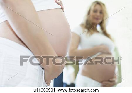 Stock Image - Pregnant woman holding belly. Fotosearch