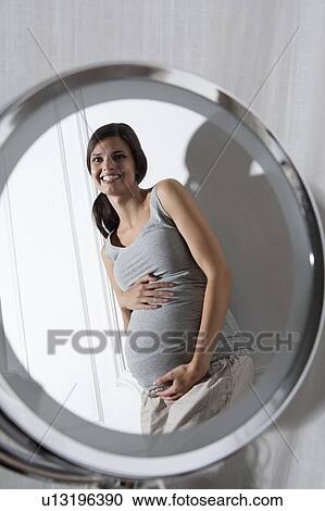 Stock Image - Pregnant woman holding belly. Fotosearch