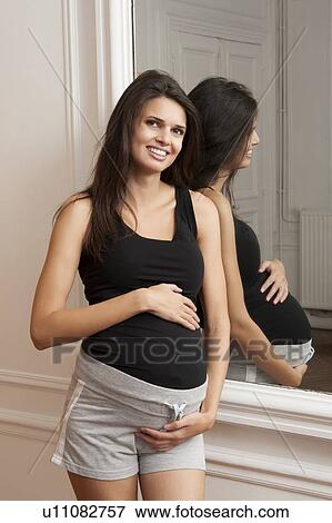 Pregnant woman holding her belly View Large Photo Image Stock Photo - Pregnant woman holding her belly. Fotosearch