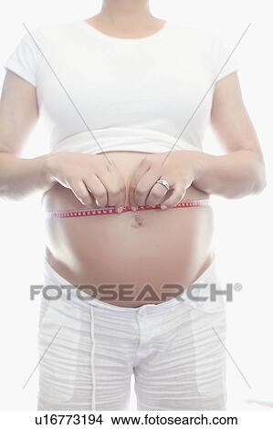 Pregnant woman measuring belly View Large Photo Image Picture - Pregnant woman measuring belly. Fotosearch