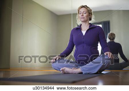 Pregnant woman practicing yoga in studio View Large Photo Image Picture - Pregnant woman practicing yoga in studio. Fotosearch
