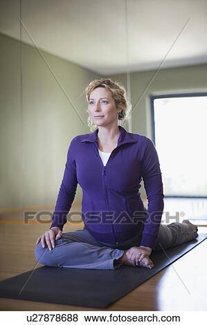 Stock Photo - Pregnant woman practicing yoga in studio. Fotosearch
