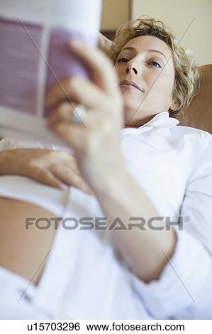 Pregnant woman reading on sofa View Large Photo Image Stock Photograph - Pregnant woman reading on sofa. Fotosearch