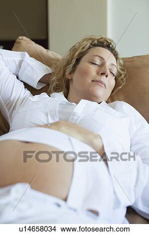 Pregnant woman sleeping on sofa View Large Photo Image Picture - Pregnant woman sleeping on sofa. Fotosearch