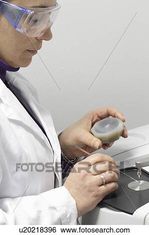 Stock Photograph - Scientist using machinery in lab. Fotosearch