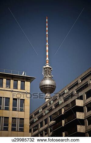 Stock Image - Sculpture towering over city buildings. Fotosearch