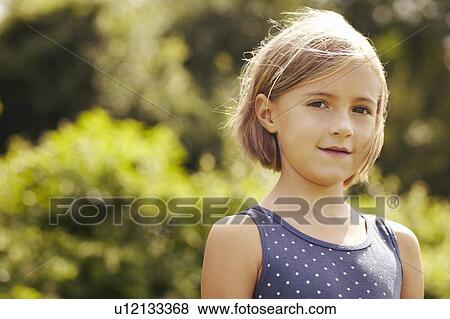Stock Photo - Smiling girl standing outdoors. Fotosearch