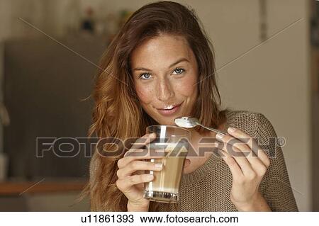 Smiling woman eating coffee foam View Large Photo Image Stock Image - Smiling woman eating coffee foam. Fotosearch