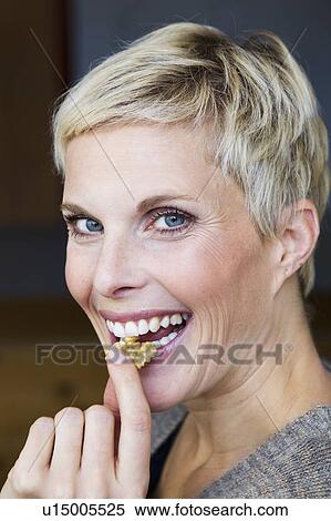 Smiling woman eating snack View Large Photo Image Stock Photography - Smiling woman eating snack. Fotosearch