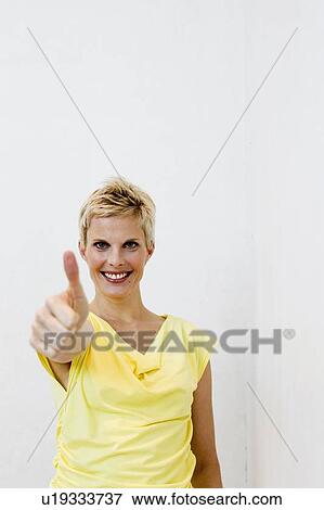 Stock Photo - Smiling woman giving? thumbs u. Fotosearch