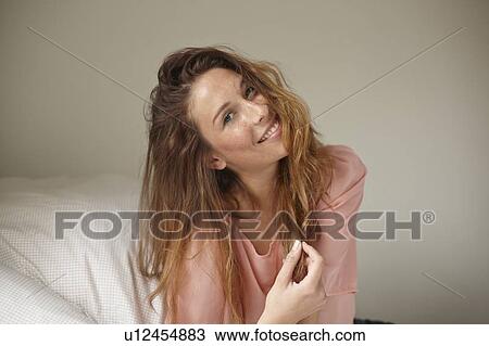 Smiling woman playing with her hair View Large Photo Image Stock Image - Smiling woman playing with her hair. Fotosearch