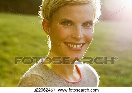 Smiling woman standing outdoors View Large Photo Image Stock Photo - Smiling woman standing outdoors. Fotosearch