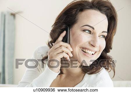 Smiling woman talking on phone View Large Photo Image Stock Photograph - Smiling woman talking on phone. Fotosearch