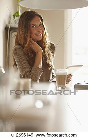 Stock Photo - Smiling woman using tablet computer. Fotosearch