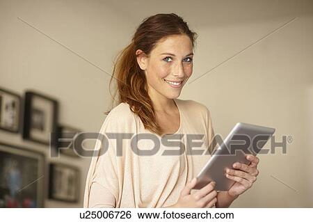 Smiling woman using tablet computer View Large Photo Image Stock Photograph - Smiling woman using tablet computer. Fotosearch