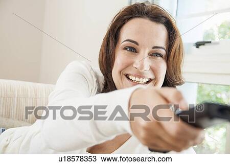 Smiling woman watching television View Large Photo Image Stock Image - Smiling woman watching television. Fotosearch