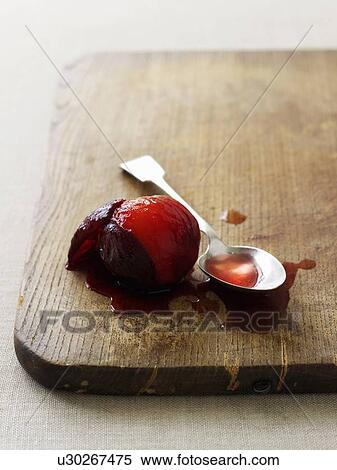 Stock Photography - Stewed plum and juice on board. Fotosearch