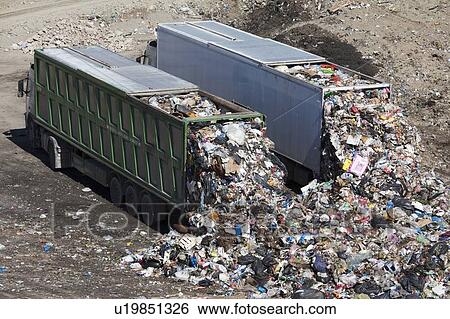 Trucks dumping waste in landfill View Large Photo Image Stock Photograph - Trucks dumping waste in landfill. Fotosearch
