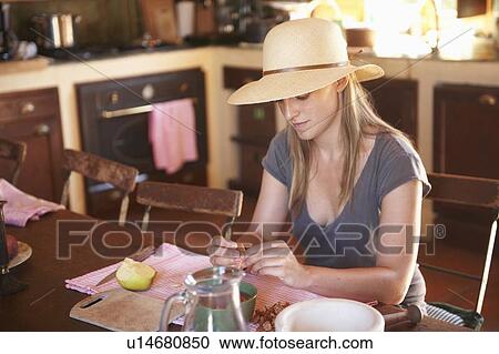 Stock Image - Woman cutting fruit at table. Fotosearch