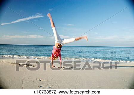 Woman doing cartwheels on tropical beach View Large Photo Image Stock Image - Woman doing cartwheels on tropical beach. Fotosearch