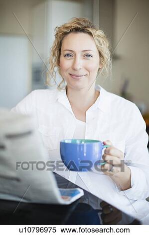 Woman drinking coffee and reading paper View Large Photo Image Stock Photography - Woman drinking coffee and reading paper. Fotosearch