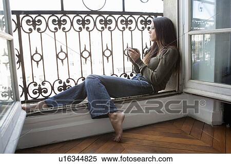 Woman drinking coffee in windowsill View Large Photo Image Stock Photography - Woman drinking coffee in windowsill. Fotosearch