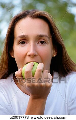 Woman eating apple outdoors View Large Photo Image Stock Image - Woman eating apple outdoors. Fotosearch