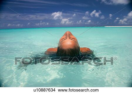 Woman floating in tropical water View Large Photo Image Picture - Woman floating in tropical water. Fotosearch