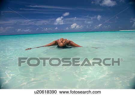 Woman floating in tropical water View Large Photo Image Stock Image - Woman floating in tropical water. Fotosearch