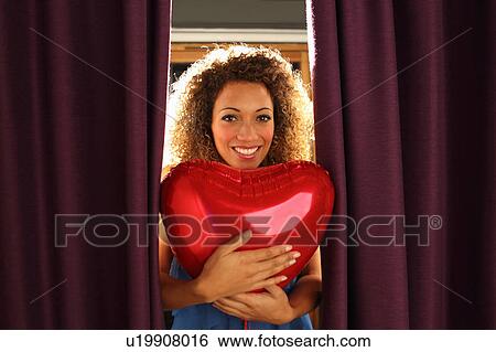 Woman holding heart shaped balloon View Large Photo Image Stock Photograph - Woman holding heart shaped balloon. Fotosearch