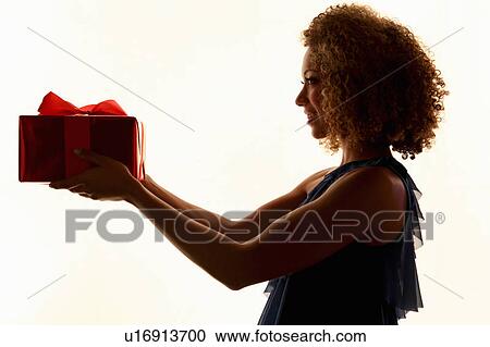 Stock Image - Woman holding wrapped gift. Fotosearch