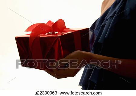 Stock Image - Woman holding wrapped gift. Fotosearch
