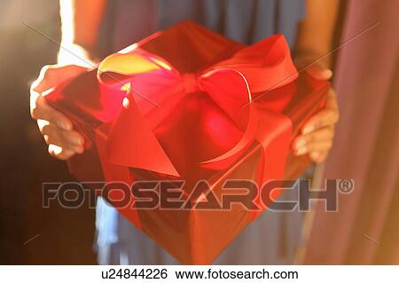 Woman holding wrapped gift View Large Photo Image Stock Photograph - Woman holding wrapped gift. Fotosearch