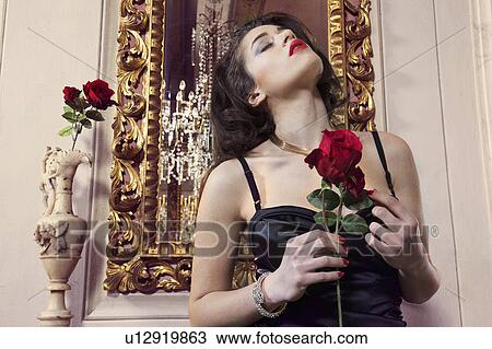 Woman in gown holding flower View Large Photo Image Stock Image - Woman in gown holding flower. Fotosearch